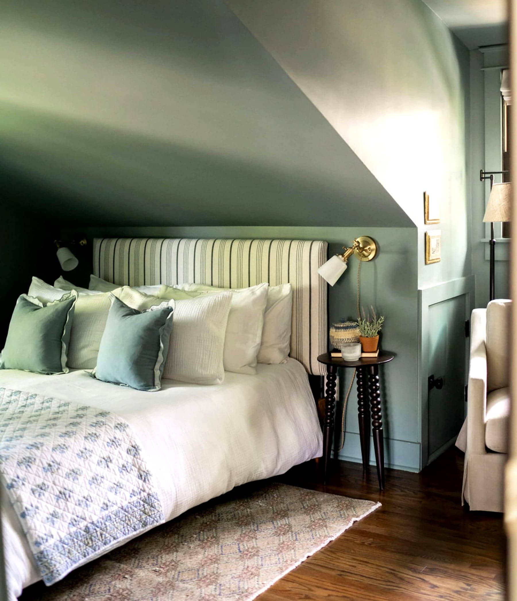 A Boost-managed Nashville bedroom — sage green panelling and a brass sconce