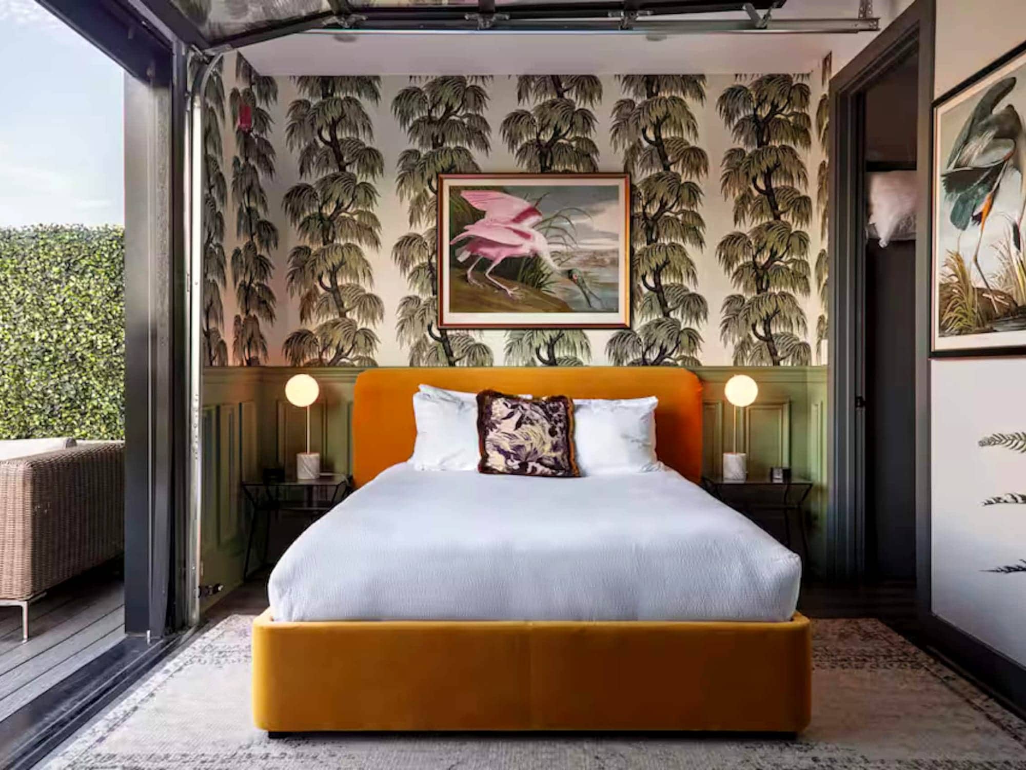 A Boost-managed Nashville studio — palm wallpaper and a mustard velvet bed